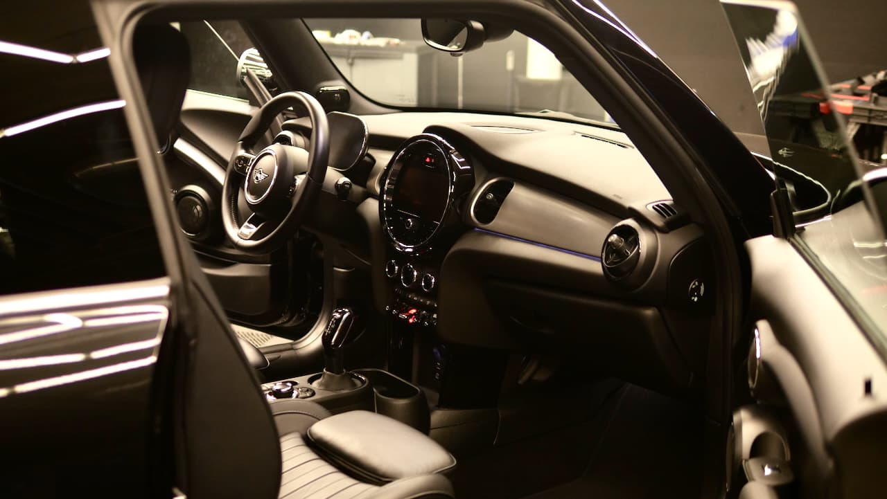 A clean Mini interior with the driver's door open in the Black Diamond studio